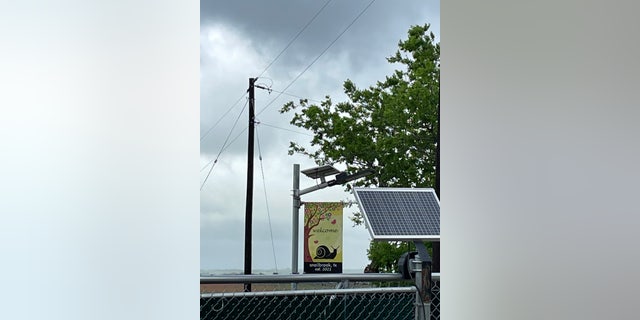 A flag at a site next to a Boring Co. facility in Bastrop, TX, reads "welcome, snailbrook, tx, est. 2021." 