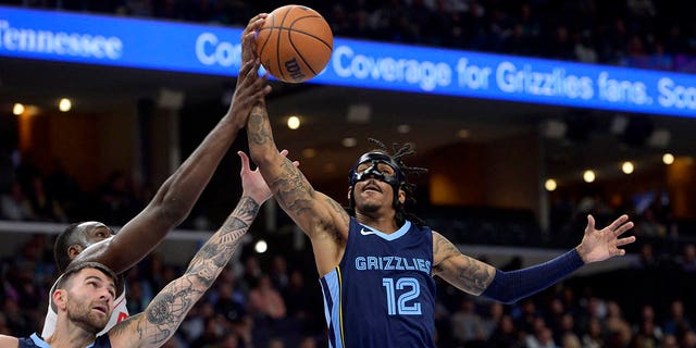 Memphis Grizzlies guards Ja Morant, #12, and John Konchar, #46, reach for a rebound in the first half of an NBA basketball game against the Houston Rockets Wednesday, March 22, 2023, in Memphis, Tennessee.