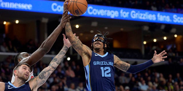 Memphis Grizzlies guards Ja Morant, #12, and John Konchar, #46, reach for a rebound in the first half of an NBA basketball game against the Houston Rockets Wednesday, March 22, 2023, in Memphis, Tennessee.