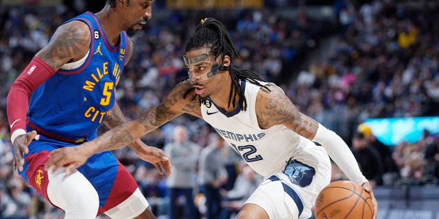 El escolta de los Grizzlies de Memphis, Ja Morant, conduce mientras el escolta de los Nuggets, Kentavious Caldwell Pope, el viernes 3 de marzo de 2023 en Denver.