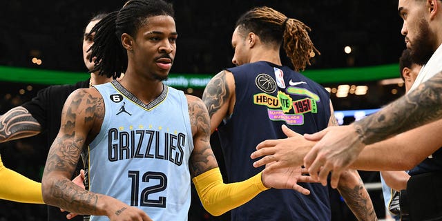 Ja Morant of the Memphis Grizzlies high-fives his teammates during a timeout at a Celtics game at TD Garden on February 12, 2023 in Boston.