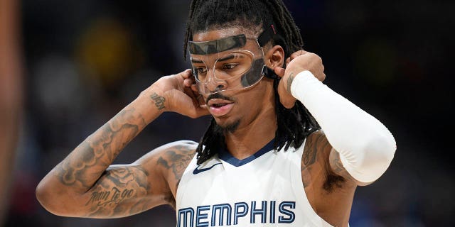 Memphis Grizzlies guard Ja Morant adjusts his protective face mask before shooting a pair of free throws against the Nuggets on Friday, March 3, 2023, in Denver.