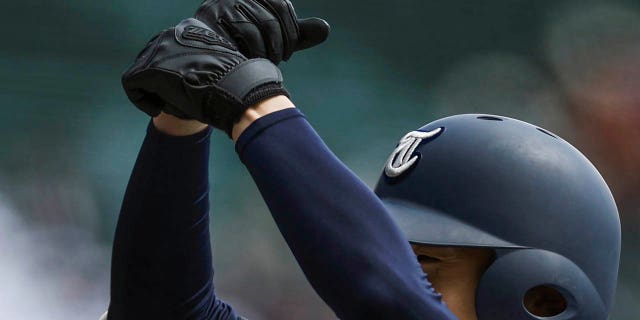 A player for Tohoku High School gestures after getting on first base during their game against Yamanashi Gakuin Senior High School at a stadium in Nishinomiya, Osaka, western Japan, Saturday, March 18, 2023.