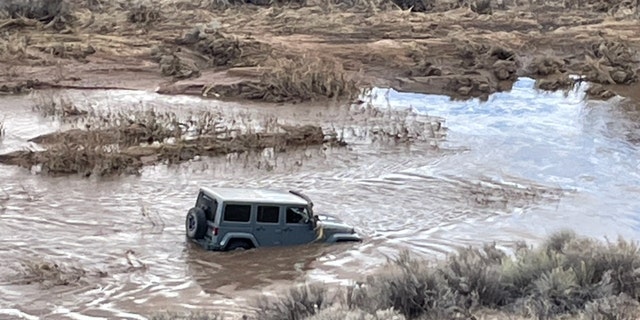 The husband reported that the swift-moving water swept the Jeep from the dirt roadway and began to push the vehicle downstream.