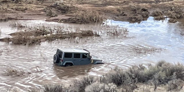 The husband reported that the swift-moving water swept the Jeep from the dirt roadway and began to push the vehicle downstream.