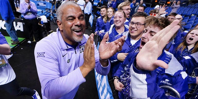 Kansas State head coach Jerome Tang celebrates with members of the cheer band after defeating Kentucky in a second round college basketball game in the NCAA Tournament on Sunday, March 19, 2023, in Greensboro, North Carolina.