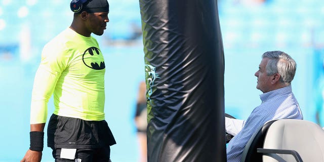 Cam Newton #1 de los Carolina Panthers habla con el dueño del equipo, Jerry Richardson, para calentar antes de su partido contra los Miami Dolphins en el Bank of America Stadium el 22 de agosto de 2015 en Charlotte, Carolina del Norte. 