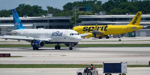 A JetBlue Airways Airbus A320, left, passes a Spirit Airlines Airbus A320 as it taxis on the runway, July 7, 2022, at the Fort Lauderdale-Hollywood International Airport in Fort Lauderdale, Florida.