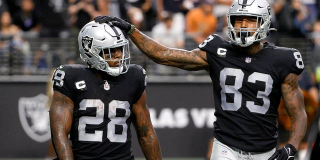Josh Jacobs, #28 of the Las Vegas Raiders, celebrates a touchdown with Darren Waller, #83, during the second half against the Chicago Bears at Allegiant Stadium on October 10, 2021 in Las Vegas.