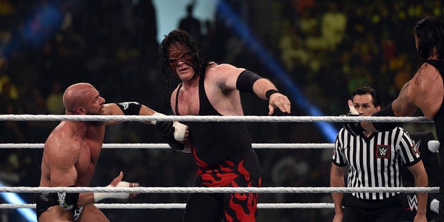 Kane, center, vies with Triple H, left, during a tag team match as part of the World Wrestling Entertainment Crown Jewel pay-per-view at the King Saud University Stadium in Riyadh on Nov. 2, 2018.