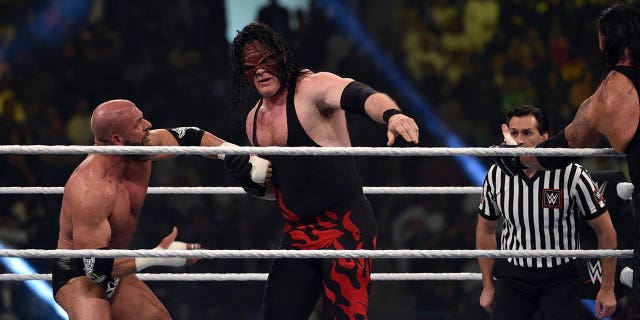 Kane, center, vies with Triple H, left, during a tag team match as part of the World Wrestling Entertainment Crown Jewel pay-per-view at the King Saud University Stadium in Riyadh on Nov. 2, 2018.