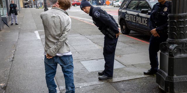 Police officers check on a man who said he has been smoking fentanyl in downtown Seattle on March 14, 2022 in Seattle, Washington. Use of the powerful opioid has surged in the last several years, especially in Seattle's large homeless community. According to a recent report commissioned by Seattle Councilmember Andrew Lewis, the COVID-19 pandemic put undue pressure on the city's shelter system and delayed funds for new housing, leading to an increase in homelessness. 