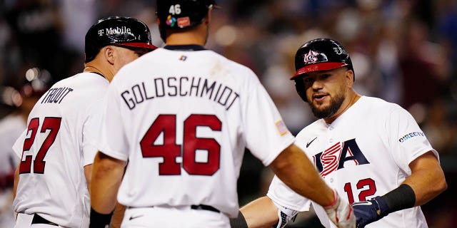 Kyle Schwarber, #12 of Team USA, is greeted by teammates Mike Trout, #27, and Paul Goldschmidt, #46, after hitting a three-run home run in the fourth inning during Game 2 of Pool C between Team Great Britain and Team USA at Chase Field on Saturday, March 11, 2023 in Phoenix.