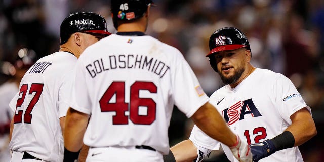 Kyle Schwarber, #12 for Team USA, is greeted by teammates Mike Trout, #27, and Paul Goldschmidt, #46, after hitting a three-run home run in the fourth inning during the Game 2 of Pool C between Team Great Britain and Team USA at Chase Field on Saturday, March 11, 2023 in Phoenix.