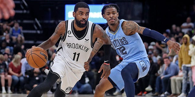 Kyrie Irving of the Brooklyn Nets goes to the basket against Ja Morant of the Grizzlies at FedExForum on Oct. 24, 2022, in Memphis, Tennessee.