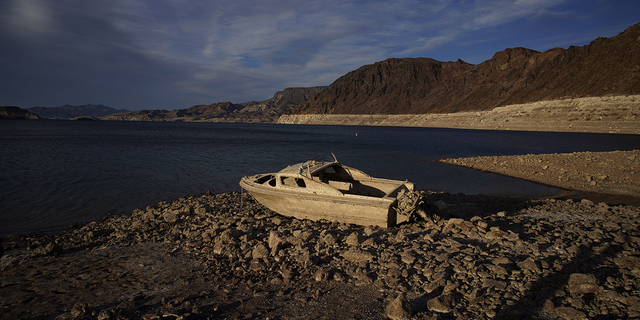 A formerly sunken boat sits along the shoreline of Lake Mead at the Lake Mead National Recreation Area in May 2022. On Tuesday, officials identified human remains found there last year.