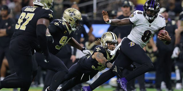 Lamar Jackson #8 de los Baltimore Ravens corre el balón mientras Teran Matthew #32 de los New Orleans Saints intenta una entrada durante el último cuarto en el Caesars Superdome el 7 de noviembre de 2022 en Nueva Orleans, Luisiana. 