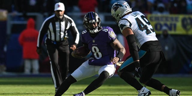 Baltimore Ravens quarterback Lamar Jackson, #8, cuts on Carolina Panthers linebacker Frankie Luvu, #49, during there game at M&T Bank Stadium in Baltimore Nov. 20, 2022.