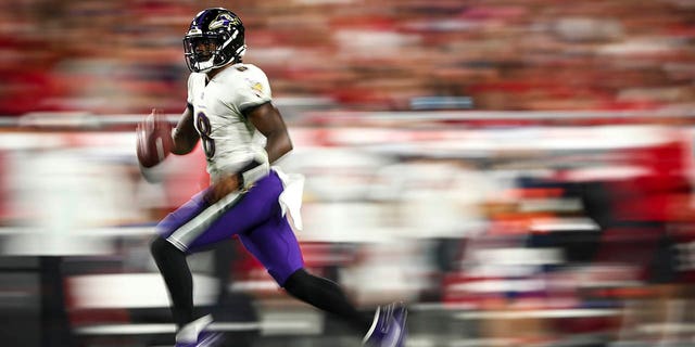 Baltimore Ravens number 8 Lamar Jackson carries the ball during the fourth quarter of an NFL football game against the Tampa Bay Buccaneers at Raymond James Stadium on October 27, 2022 in Tampa, Florida. 