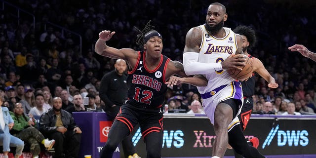 Los Angeles Lakers forward LeBron James drives to the basket past Chicago Bulls guard Ayo Dosunmu, #12, during the second half of an NBA basketball game, Sunday, March 26, 2023, in Los Angeles.