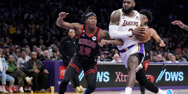 Los Angeles Lakers forward LeBron James drives to the basket past Chicago Bulls guard Ayo Dosunmu, #12, during the second half of an NBA basketball game, Sunday, March 26, 2023, in Los Angeles.