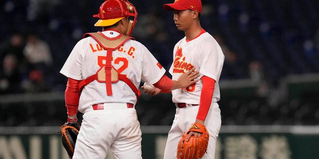 Luan Chenchen, left, talks to Sun Hailing on the mound during the fourth inning of the first round Pool B game between the South Korea and China at the World Baseball Classic at the Tokyo Dome in Tokyo Monday, March 13, 2023.