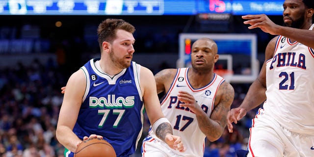 The Dallas Mavericks' Luka Doncic handles the ball as the Philadelphia 76ers' Joel Embiid, far right, and P.J. Tucker defend in the second half of the game at American Airlines Center in Dallas on Thursday.