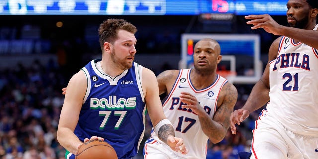 Luka Doncic, de los Dallas Mavericks, maneja el balón mientras Joel Embiid, extremo derecho, y PJ Tucker, de los Philadelphia 76ers, defienden en la segunda mitad del partido en el American Airlines Center en Dallas el jueves.