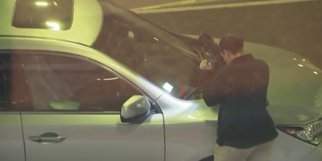 Investigators photograph the inside of Vishwachand Kolla's Acura SUV at the scene where he was struck and killed by a coach bus.