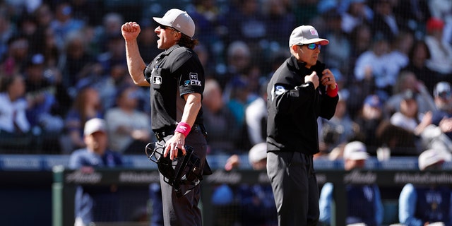 Umpire Chris Guccione #68 calls for an out after a video replay during the game between the Seattle Mariners and the Tampa Bay Rays at T-Mobile Park on May 08, 2022 in Seattle, Washington.