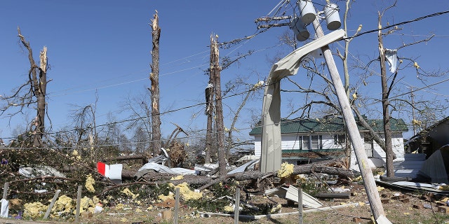 Insulation and tin are seen stuck and wrapped around the remains of trees near the intersection of Highways 25 and 6 in Amory Miss., Saturday, March 25, 2023, after it was hit by a severe storm the night before.