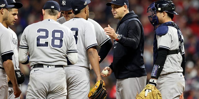 Manager Aaron Boone #17 of the New York Yankees takes the ball from Wandy Peralta #58 during the ninth inning against the Cleveland Guardians in game three of the American League Division Series at Progressive Field on October 15, 2022 in Cleveland , Ohio.