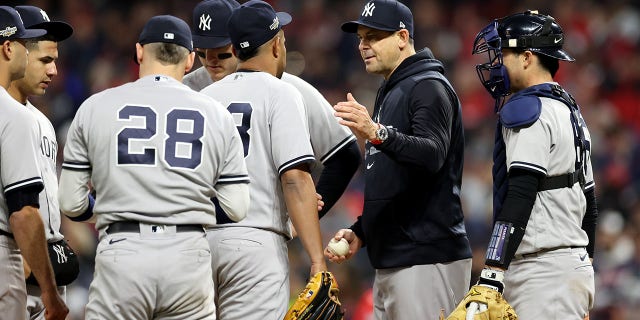 El mánager de los Yankees de Nueva York, Aaron Boone #17, toma el balón de Wandy Peralta #58 en la novena entrada contra los Guardianes de Cleveland en el Juego 3 de la Serie Divisional de la Liga Americana en Progressive Field el 15 de octubre de 2022 en Cleveland, Ohio.