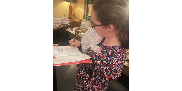 Stolen Youth co-author signing books with her newborn baby.