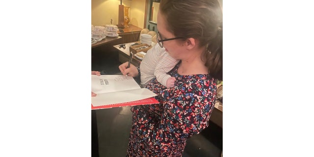 Stolen Youth co-author signing books with her newborn baby.