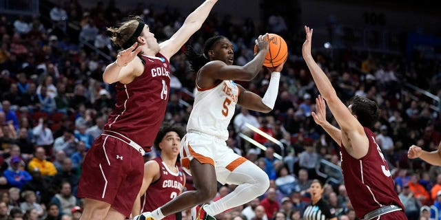 Texas guard Marcus Carr, center, passes between Colgate forward Keegan Records, left, and guard Oliver Lynch-Daniels, right, in the second half of a first-round college basketball game in the NCAA Tournament, Thursday, March 16, 2023, in Des Moines, Iowa.