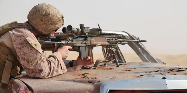 Lance Cpl. Matthew Long, a scout sniper, fires an M39 enhanced marksmanship rifle at a marksmanship training event in Kuwait in 2012. The Marines will now house their snipers in reconaissance battalions instead of infantry battalions, according to the Marine Corps Times.