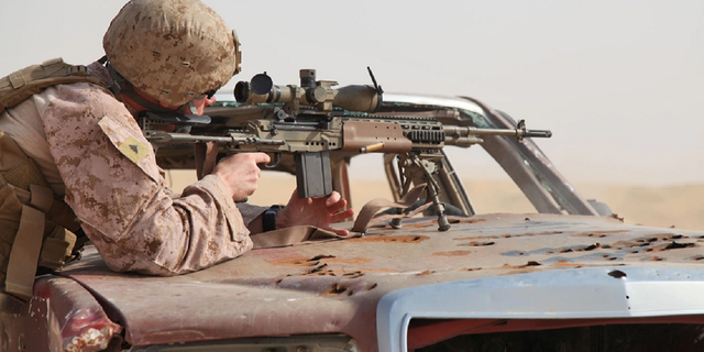 Lance Cpl. Matthew Long, a scout sniper, fires an M39 enhanced marksmanship rifle at a marksmanship training event in Kuwait in 2012. The Marines will now house their snipers in reconaissance battalions instead of infantry battalions, according to the Marine Corps Times.