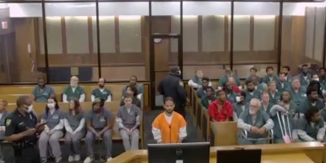 Mario Fernandez wears an orange jail-issue jumpsuit in court.