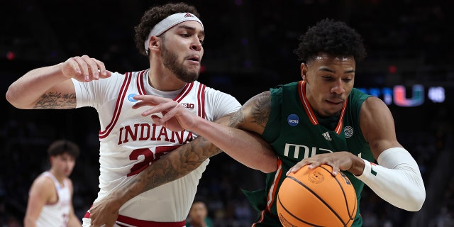 Jordan Miller #11 of the Miami Hurricanes handles the ball against Race Thompson #25 of the Indiana Hoosiers in the second half during the second round of the NCAA Men's Basketball Tournament at MVP Arena on March 19, 2023, in Albany, New York.