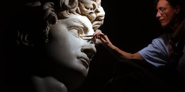 Restorer cleans Michelangelo''s masterpiece "David" during restoration work at the Galleria dell''Accademia October 6, 2003 in Florence, Italy.