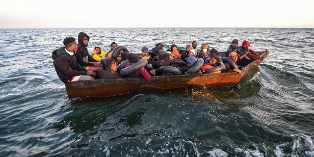 FILE: Migrants from sub-Saharan Africa sit in a makeshift boat that was being used to clandestinely make its way towards the Italian coast. 