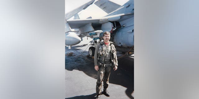 Navy A-6 Intruder pilota Jim Seaman in piedi davanti al suo jet.  È morto di cancro ai polmoni all'età di 61 anni nel 2018. 