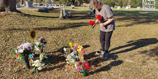 Minnie Artis lays flowers at the Hampton Cemetery where Maggie and Paul Murdaugh are buried, Sunday, March 5, 2023. The mother and son were killed by Alex Murdaugh in 2021.