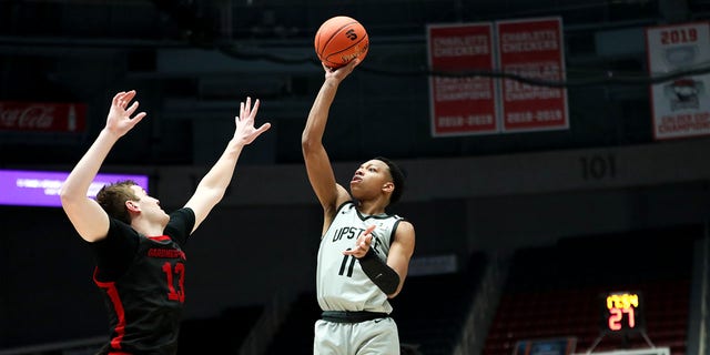 Jordan Gainey (11) of the USC Upstate Spartans shoots the ball over Lucas Stieber (13) of the Gardner-Webb Runnin' Bulldogs during the Big South Tournament on March 3, 2023, at Bojangles Coliseum in Charlotte, NC 