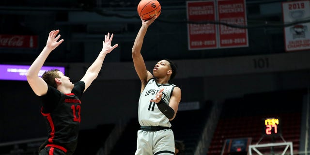 Jordan Gainey (11) of the USC Upstate Spartans shoots the ball over Lucas Stieber (13) of the Gardner-Webb Runnin' Bulldogs during the Big South Tournament on March 3, 2023, at Bojangles Coliseum in Charlotte, NC 