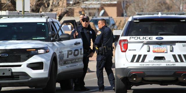 Police work outside a home on Feb. 23, 2023, in Albuquerque, N.M., where they found two people stabbed and another person dead of a self-inflicted gunshot wound.