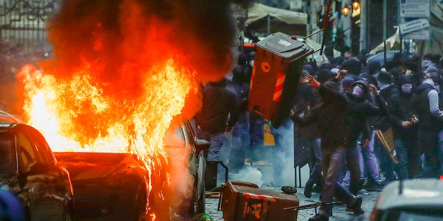 Aficionados del equipo de fútbol Eitracht Frankfurt chocan con la policía el miércoles 15 de marzo de 2023 en Nápoles, sur de Italia, donde su equipo se prepara para jugar el partido de vuelta de los octavos de final de la Liga de Campeones contra el Napoli.