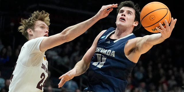 Nick Davidson de Nevada dispara contra Duke Brennan de Arizona State en la primera mitad de un partido de baloncesto universitario de los primeros cuatro en el Torneo de Baloncesto Masculino de la NCAA el miércoles 15 de marzo de 2023 en Dayton, Ohio. 