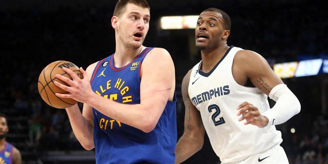 Denver Nuggets center Nikola Jokic (15) drives to the basket defending Memphis Grizzlies forward Xavier Tillman (2) during the first half at the FedEx Forum on February 25, 2023 in Memphis.